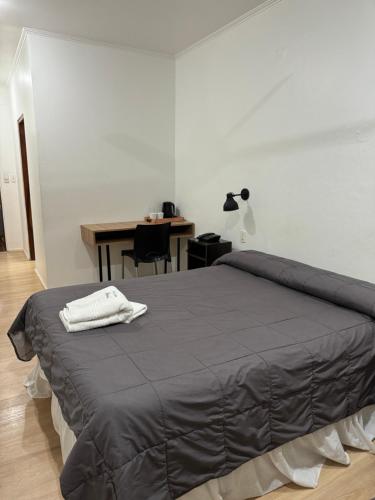a bedroom with a bed with a table and a lamp at Hotel Milton in La Paz