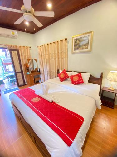 a bedroom with a large bed with a red blanket at Luangprabang Villa Kee Lee in Luang Prabang