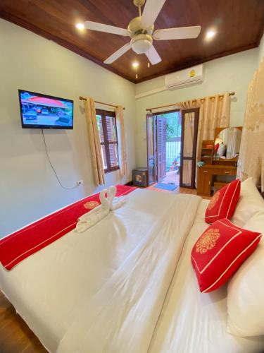 a large white bed in a bedroom with a ceiling fan at Luangprabang Villa Kee Lee in Luang Prabang