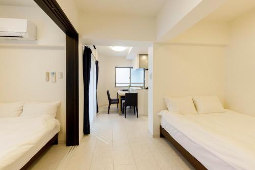 a hotel room with two beds and a table at Live Casa Tokyo浜松町 - Direct Haneda Monorail - Near Tokyo Tower - 1 Stop to Shinkansen in Tokyo