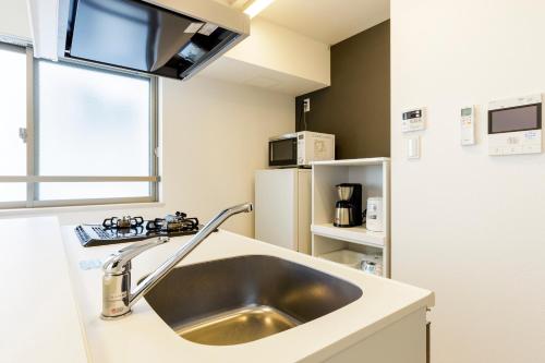 a kitchen with a sink and a refrigerator at Live Casa Tokyo浜松町 - Direct Haneda Monorail - Near Tokyo Tower - 1 Stop to Shinkansen in Tokyo