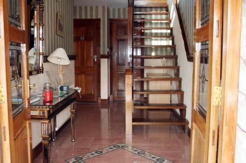 einen Flur mit einer Treppe in einem Haus mit einem Schreibtisch in der Unterkunft Ceecliff House in Culdaff