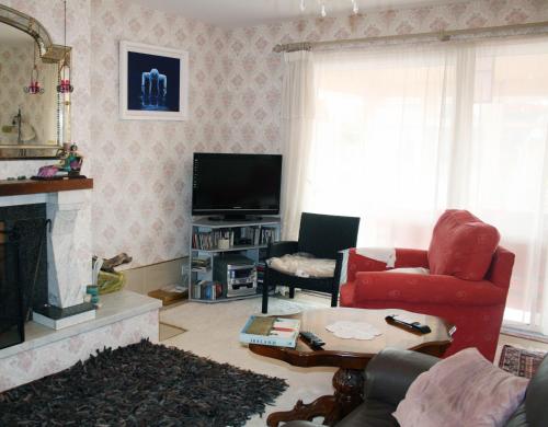 sala de estar con silla roja y chimenea en Ceecliff House en Culdaff
