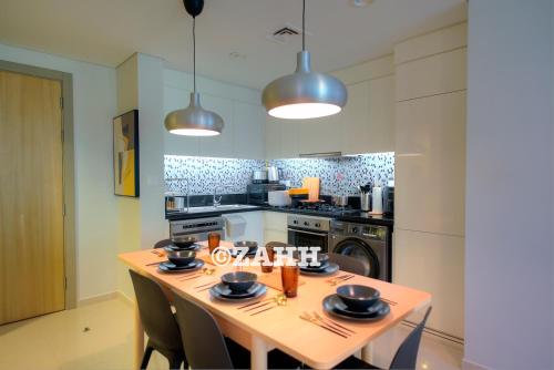 a kitchen with a wooden table with chairs and appliances at Business Bay Retreat in Dubai
