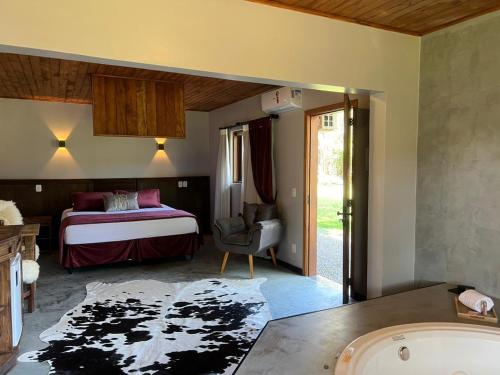 a bedroom with a bed and a tub in a room at Hotel Cabanas Glamour in Gramado