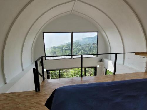 a bedroom with a large window and a bed at Tierra Vital Atenas Villa 2 in Atenas