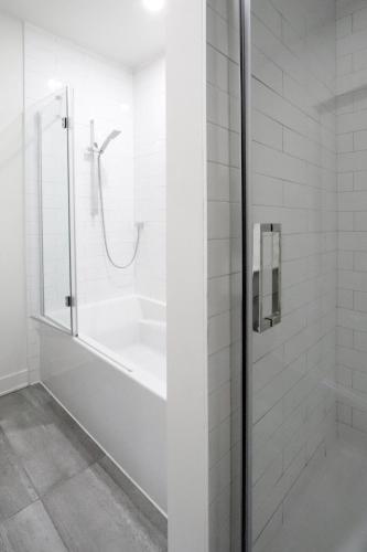 a shower with a glass door in a bathroom at Appartement de luxe avec piscine in Montréal