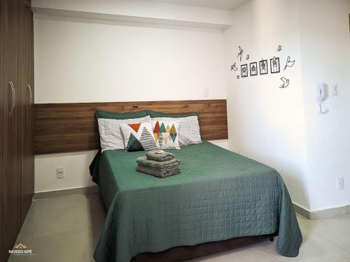 une chambre avec un lit avec une couette verte dans l'établissement Nosso Apê 915: Piscina | Academia | Coworking - NA2103, à Juiz de Fora
