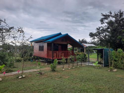 a small house with a blue roof in a yard at Lucky Bungalow in Khao Lak