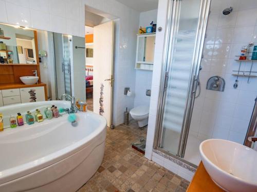 La salle de bains est pourvue d'une baignoire, d'une douche et de toilettes. dans l'établissement Villa d'Exception: Piscine Chauffée, SPA, pour 14, à 5 min du Lac d’Hossegor - FR-1-791-20, à Soorts-Hossegor