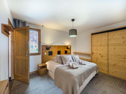 une chambre avec un lit avec une tête de lit en bois dans l'établissement Appartement avec Piscine, Sauna et Terrasse aux Saisies - FR-1-809-1, aux Saisies
