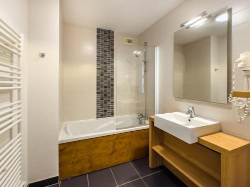 une salle de bain avec un lavabo et une baignoire dans l'établissement Appartement avec Piscine, Sauna et Terrasse aux Saisies - FR-1-809-1, aux Saisies