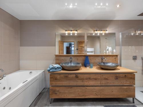 deux lavabos sur un comptoir en bois dans une salle de bain dans l'établissement Loft spacieux avec spa, piscine, salle de sport et parking - FR-1-809-4, aux Saisies