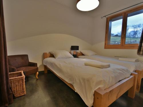 - 2 lits dans une chambre avec une chaise et une fenêtre dans l'établissement Appartement 6 pers, 3 ch, parking, proche pistes - Grand-Bornand - FR-1-467-128, au Grand-Bornand