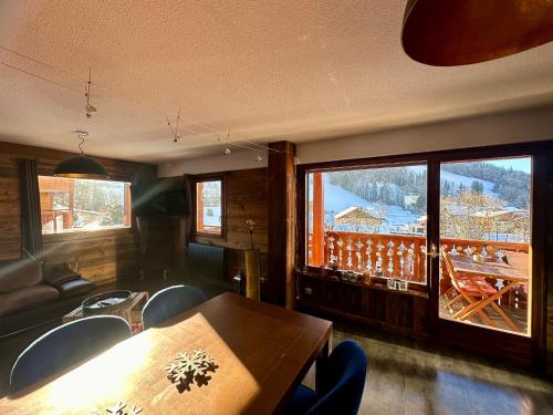 une salle à manger avec une table et des chaises et un balcon dans l'établissement Appartement 6 pers, 3 ch, parking, proche pistes - Grand-Bornand - FR-1-467-128, au Grand-Bornand