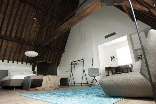 a bedroom with a bed and a desk and a chair at Hotel Katoen in Goes