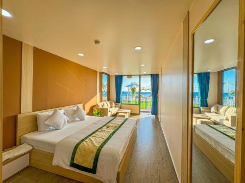 a hotel room with a bed and a living room at Queen Sea Resort - Đảo Phú Quý in Cu Lao Thu