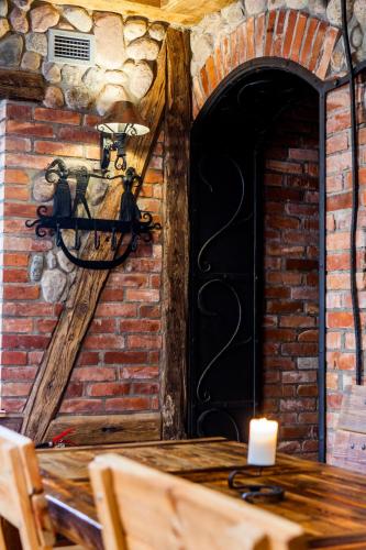 a room with a brick wall with a candle on a table at Mùlk Chëcz Kaszëbsko in Miszewko