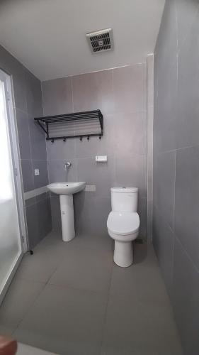 a bathroom with a toilet and a sink at Beach Hotel Wirton Batukaras in Batukaras