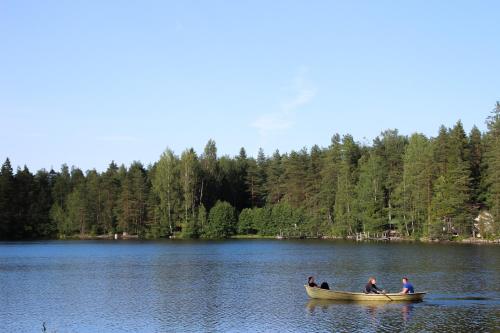 a group of people in a boat on a lake at Hotelli Lepolampi in Espoo