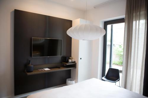 a bedroom with a bed and a tv and a chair at Hotel Katoen in Goes