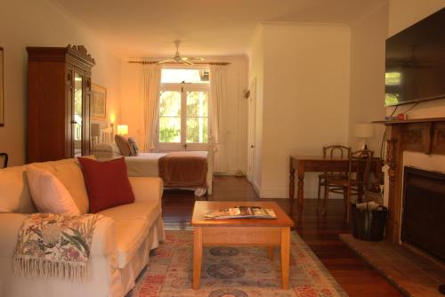 a living room with a couch and a fireplace at The Carriages Boutique Hotel and Vineyard in Pokolbin