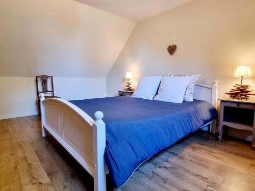 una camera da letto con letto con lenzuola blu e cuscini bianchi di Gîte au calme avec jardin, Wifi et parking près de Lille - FR-1-510-222 a Fournes-en-Weppes