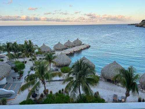 an aerial view of a beach with huts and the ocean at Blue Emerald Ocean's 8 in Willemstad