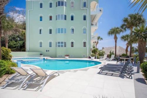 a hotel with a swimming pool and chairs and a building at Blue Emerald Ocean's 8 in Willemstad