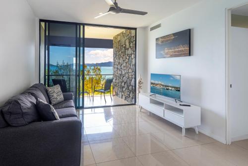 a living room with a couch and a tv at Edge Apartments on Hamilton Island by HIHA in Hamilton Island