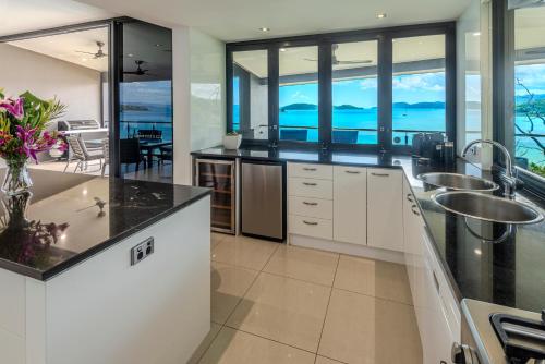 a kitchen with two sinks and a view of the ocean at Edge Apartments on Hamilton Island by HIHA in Hamilton Island