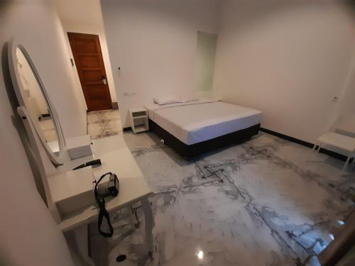 a bedroom with a bed and a marble floor at Beach Hotel Wirton Batukaras in Batukaras