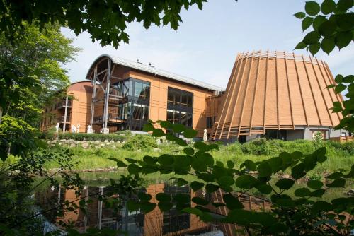 an office building with a pond in front of it at Hôtel-Musée Premières Nations in Wendake