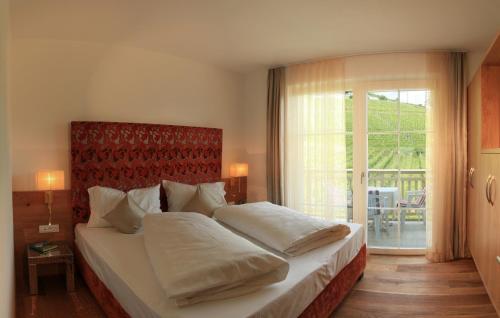 a bedroom with a large bed and a large window at Überbacherhof in Termeno