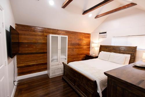 a bedroom with a bed and a wooden wall at The Caroline Suite in Key West