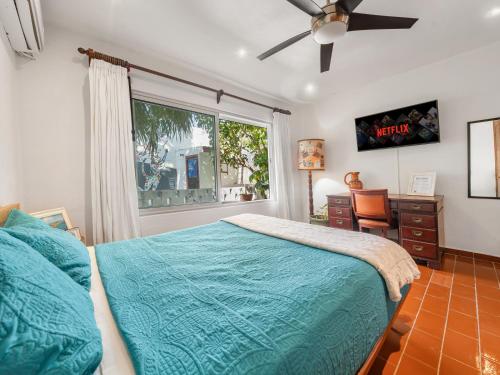 a bedroom with a bed and a window and a desk at The Mermaid and The Pearl Boutique Hotel in Isla Mujeres