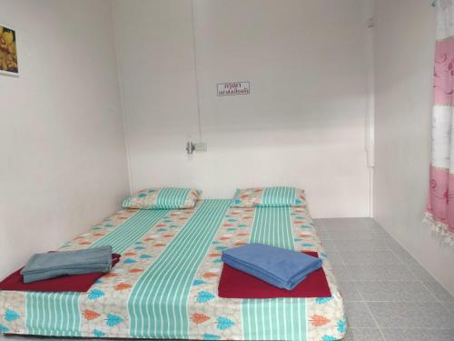 a bed with two pillows on it in a room at Canaan in Kanchanaburi