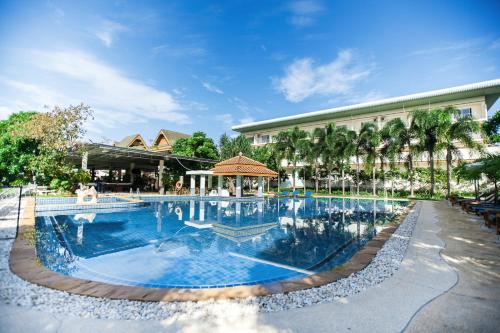 a large swimming pool in front of a building at Blue Beach Grand Resort And Spa in Rawai Beach