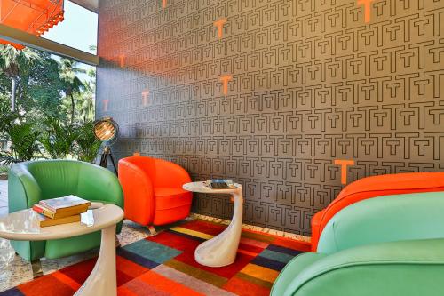 a room with chairs and a table and a wall at T24 Residency Mumbai International Airport Hotel in Mumbai