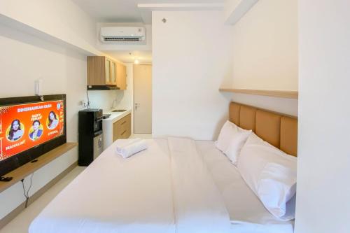 RawalembangRelaxing and Cozy Studio Tokyo Riverside PIK 2 Apartment By Travelio的一间有一张床和一台电视的小房间