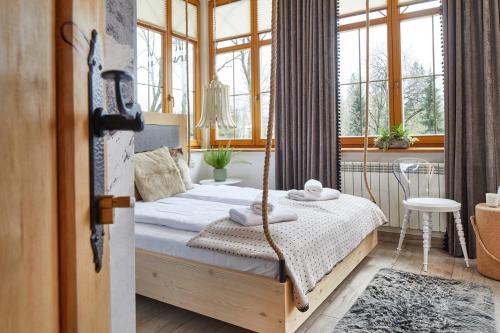 a bedroom with a bed with a swing at Niedźwiedzia Residence Garden Sauna in Poronin