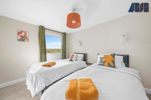 two beds in a room with a window at Mount Pleasant Haven in Leslie