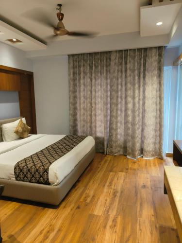 a bedroom with a bed and a large window at Hotel The Pearl, City Center - Traveler's Choice Award Winner for 2025 in New Delhi
