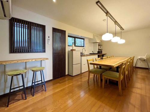 a kitchen and dining room with a wooden table and chairs at bLOCAL Bingo Yamamo - Experience at Traditional Japanese House in Onomichi
