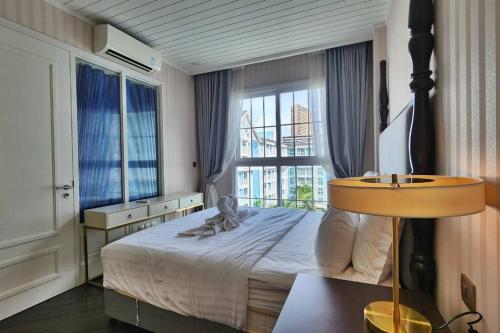 ein Schlafzimmer mit einem großen Bett mit einem großen Fenster in der Unterkunft Grand Florida 1 Bedroom Condo close to Beach - G610 in Na Jomtien