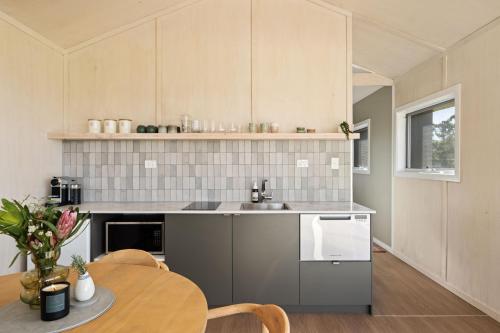 a kitchen with a sink and a table with chairs at Alkira Cottage in Ballandean