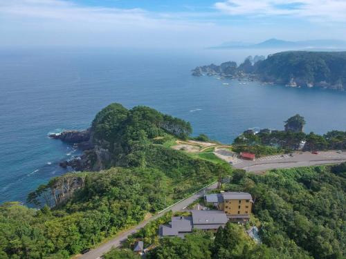 a building on a hill next to the ocean at Nagisatei Taroan in Miyako