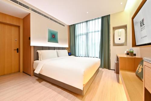 a bedroom with a large white bed and a window at 秋果智选酒店 北京上地农业大学店 in Beijing