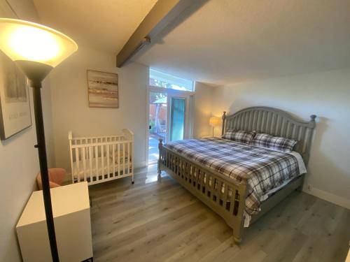 a bedroom with a bed and a lamp and a crib at NEW cozy beautiful house with pool and hot tub in Fair Oaks
