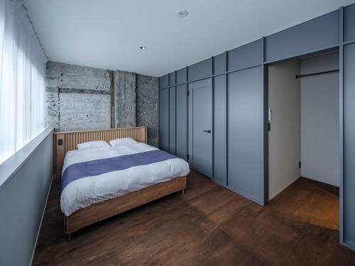 a bedroom with a bed and blue cabinets at Arcade Hotel in Fuji